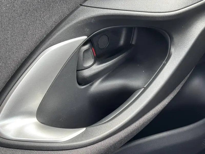 Poignée intérieure de porte côté gauche en plastique noir et argent du Toyota Yaris 116h Dynamic 5p MC24 blanc 2025.