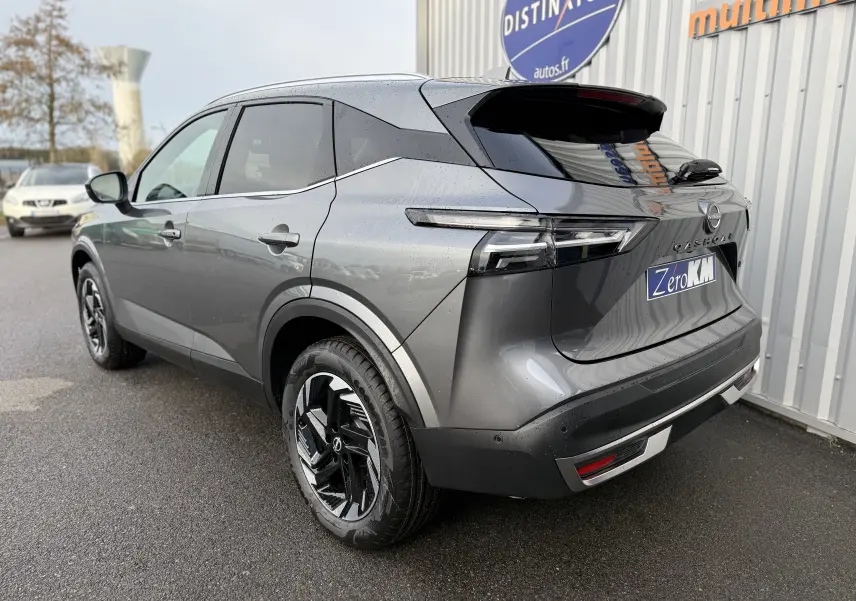 Vue 3/4 arrière droit du Nissan Qashqai 1.5 E-POWER gris squale métal avec jantes noires et toit noir brillant.