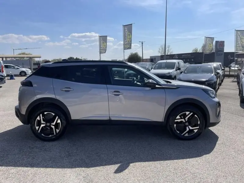 Vue de profil côté gauche d'un Peugeot 2008 gris métal 2025 avec toit noir et jantes alliage distinctives.