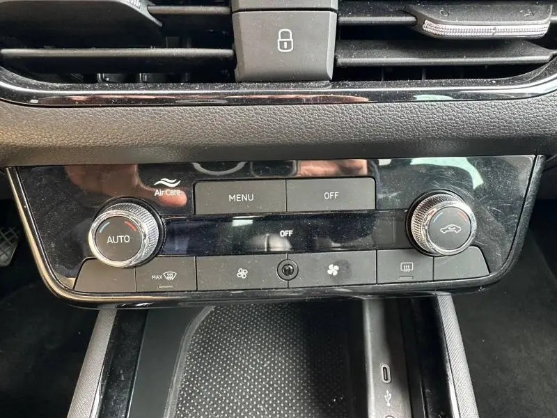 Vue rapprochée de la console centrale noire brillante avec commandes climatisation automatique de la Skoda Scala blanc cristal.
