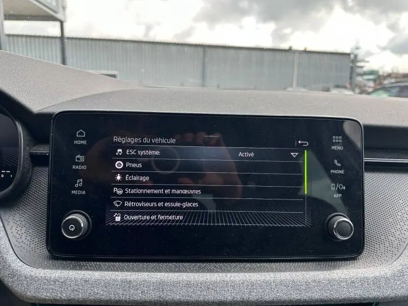 Écran tactile central du tableau de bord de la Skoda Scala blanc cristal, affichant les réglages du véhicule.
