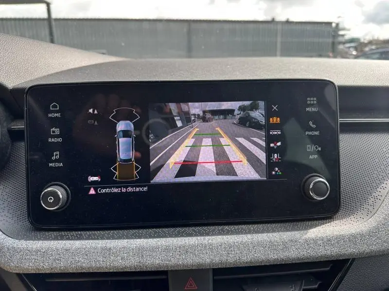 Écran tactile intérieur de la Skoda Scala blanc cristal montrant la caméra de recul avec guidage couleur.