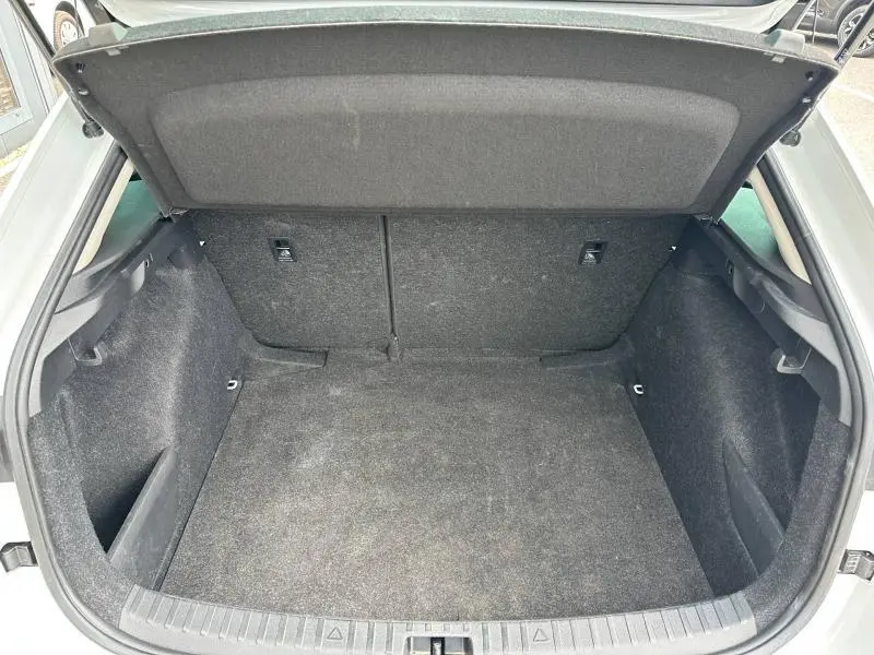Coffre ouvert vu de face d'une Skoda Scala blanc cristal, avec intérieur de coffre en tissu noir.