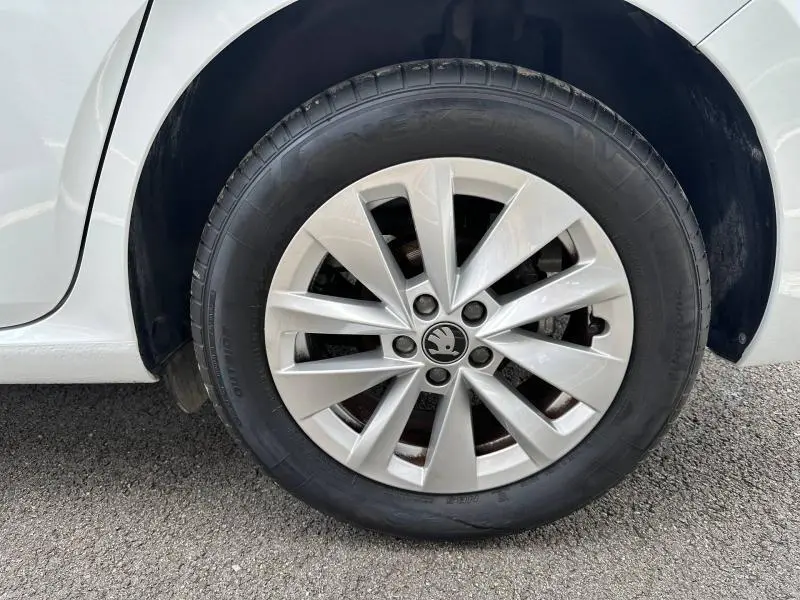 Gros plan sur la roue avant gauche d'une Skoda Scala blanche avec jante alliage à dix branches.