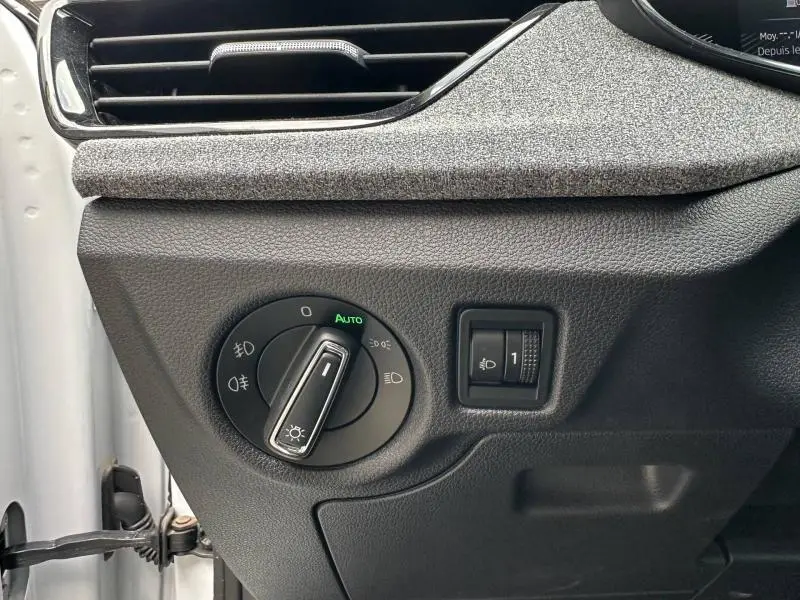 Détail du tableau de bord côté gauche avec commande des phares en mode automatique sur Skoda Scala blanc cristal 2025.