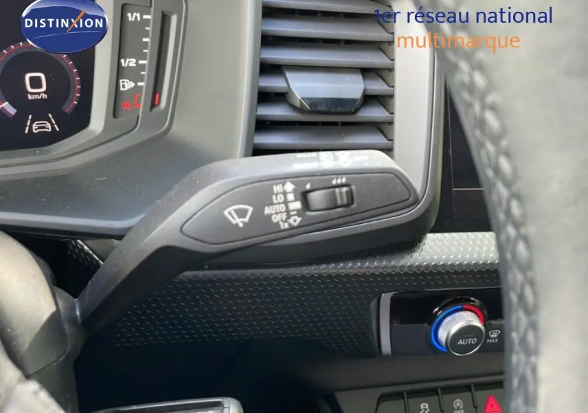 Détail du commodo d’essuie-glace et tableau de bord numérique d’une Audi A1 Sportback noire, vue intérieure côté conducteur.