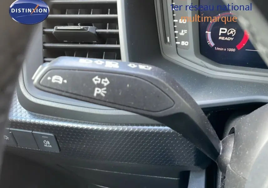 Gros plan sur la commande de clignotant à gauche dans l’habitacle noir de l’Audi A1 Sportback 2023.