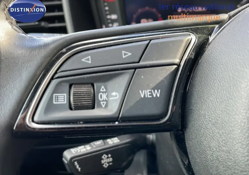 Gros plan sur les commandes au volant noir de l'Audi A1 Sportback 2023, mettant en valeur les boutons multifonctions.
