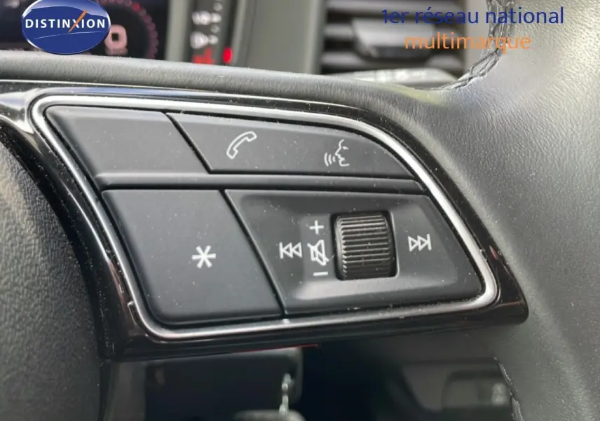 Gros plan sur les commandes au volant de l'Audi A1 Sportback noir Mythe Metal, mettant en valeur les boutons de volume et appel.