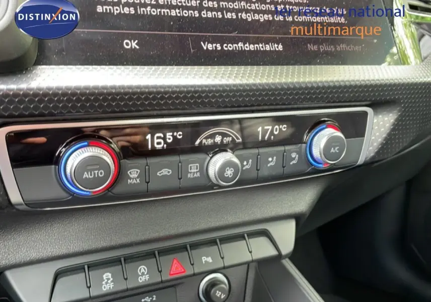 Gros plan sur la commande de climatisation digitale de l’Audi A1 Sportback 2023 avec réglages de température et boutons fonctionnels.