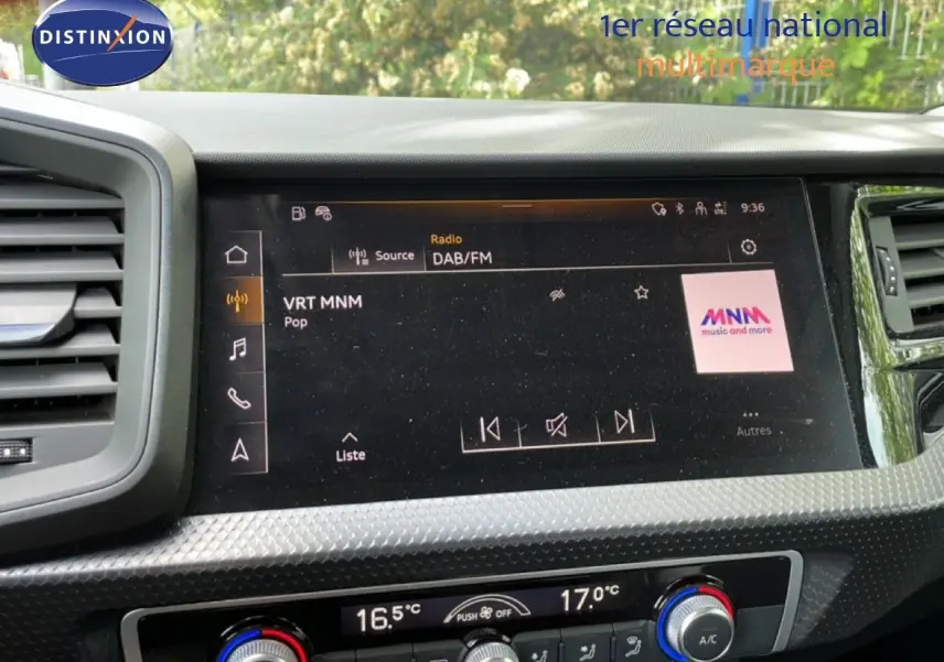 Vue rapprochée de l’écran multimédia et de la console de climatisation d’une Audi A1 Sportback noire, intérieur moderne.