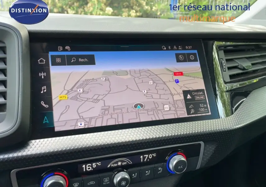 Vue rapprochée de l’écran tactile central et de la console de climatisation d’une Audi A1 Sportback noire, affichant un GPS.