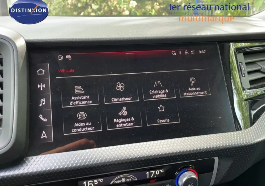 Écran tactile central de l’Audi A1 Sportback 2023 affichant les réglages du véhicule, avec tableau de bord noir et détails argentés.