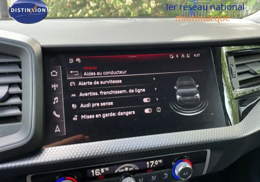Écran central de l’Audi A1 Sportback 2023 affichant les aides à la conduite, avec tableau de bord noir et détails texturés.
