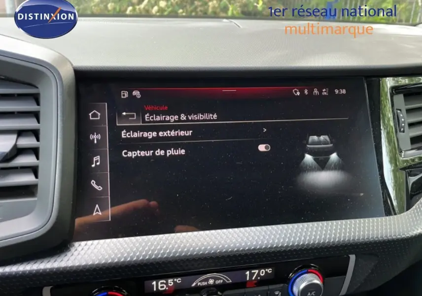Vue rapprochée de l'écran tactile central de l'Audi A1 Sportback 2023 noir mythe metal, affichant les réglages d'éclairage et capteur de pluie.
