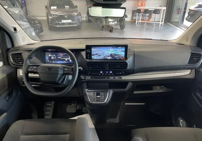 Vue intérieure avant du Peugeot Expert Fourgon 2026, tableau de bord noir avec écran tactile central et volant multifonction.