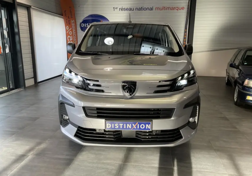 Vue frontale du Peugeot Expert Fourgon gris Artense, mettant en valeur sa calandre moderne et ses phares LED allumés.