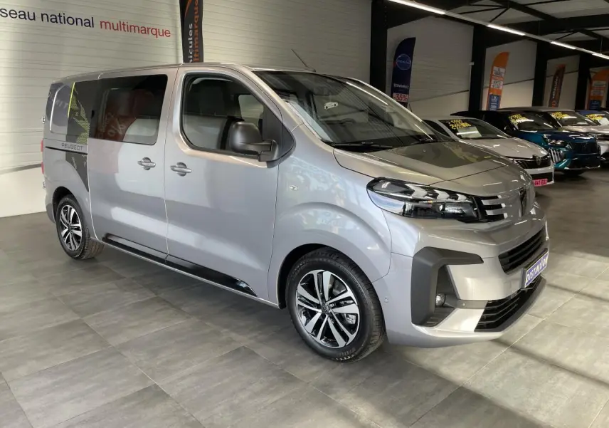 Vue 3/4 avant droit du Peugeot Expert Fourgon gris Artense avec jantes alliage et porte latérale coulissante gauche visible.