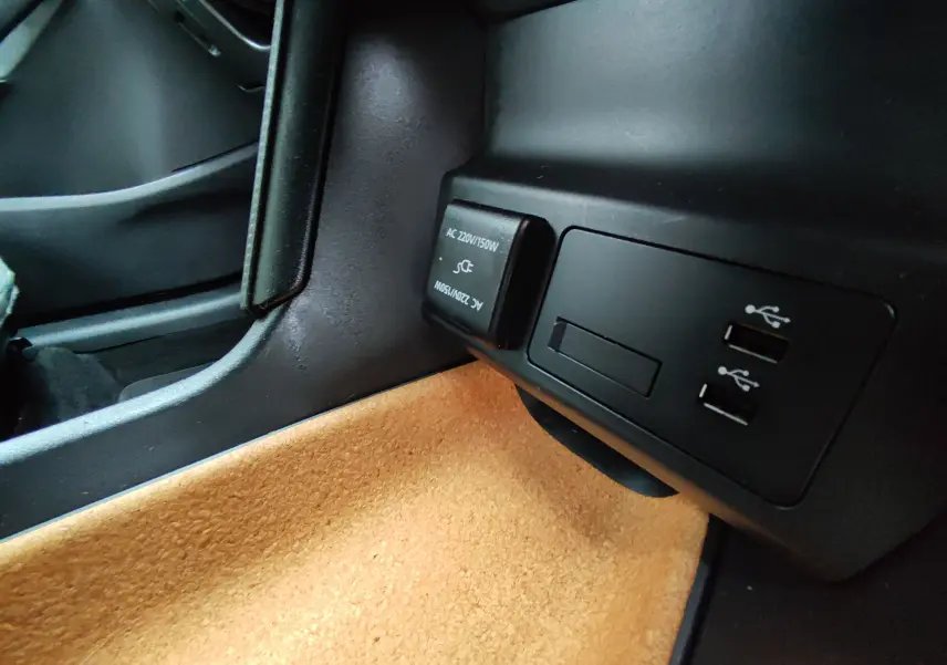 Prise USB et prise secteur 220V dans l’habitacle du Mazda MX-30 gris clair, vue côté passager.