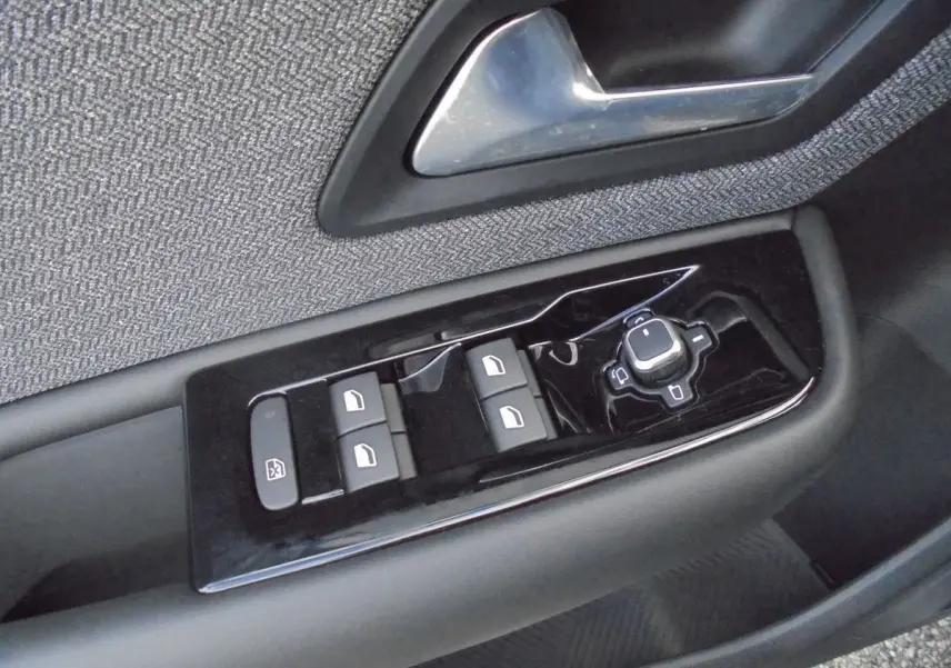 Gros plan sur les commandes de lève-vitres et rétroviseurs côté gauche d'une Citroën C5 X 2022, finition tissu gris.