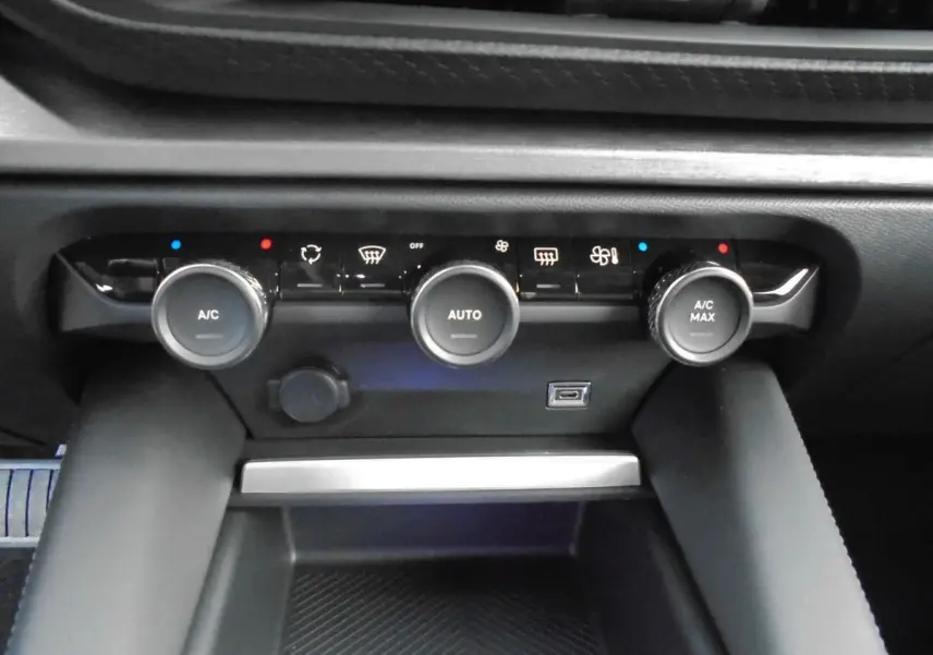 Commandes de climatisation automatique avec trois boutons rotatifs et port USB sur la console centrale d'une Citroën C5 X blanche nacrée.