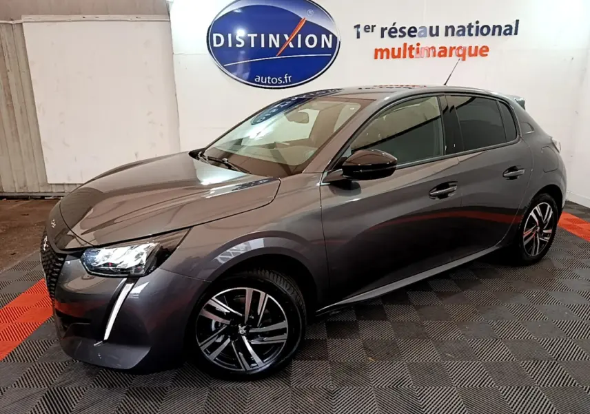 Peugeot 208 gris foncé vue 3/4 avant droit, avec jantes alliage et phares LED distinctifs.