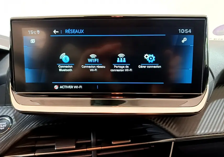 Écran tactile central de la Peugeot 208 gris foncé, affichant les options de connexion Bluetooth et Wi-Fi.