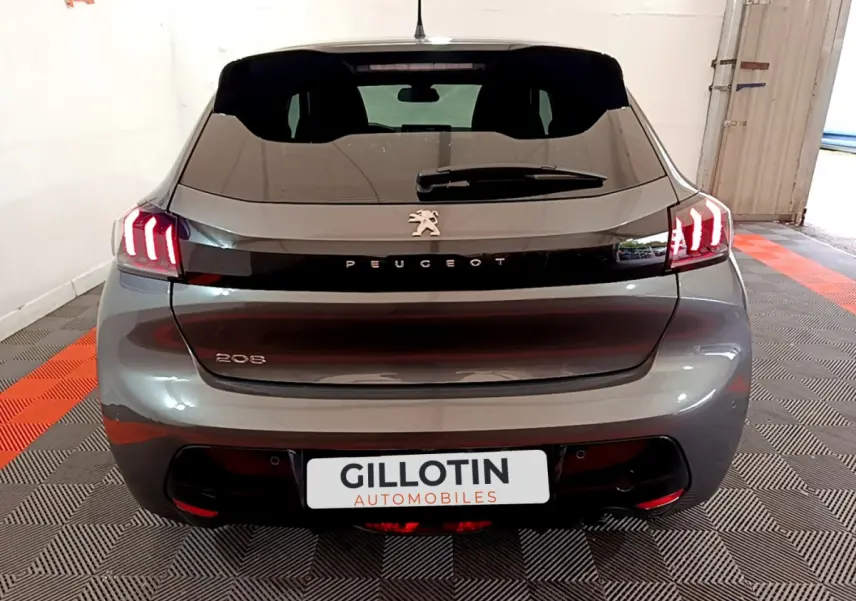 Vue arrière d’une Peugeot 208 gris foncé avec feux LED caractéristiques et logo Peugeot visible.