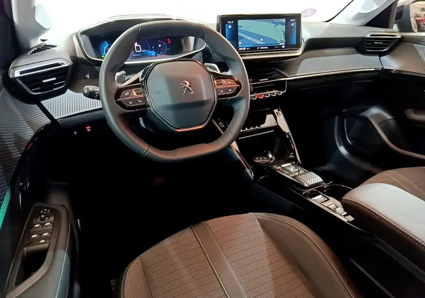 Intérieur de la Peugeot 208 2022 vu côté conducteur, volant cuir, tableau de bord numérique et écran tactile central.