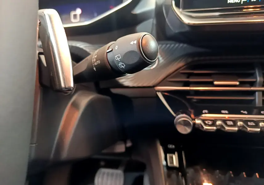 Gros plan sur la commande d’essuie-glace côté gauche du tableau de bord noir de la Peugeot 208 2022.