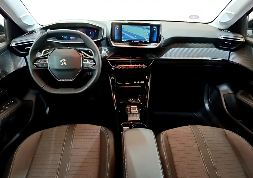 Intérieur Peugeot 208 2022 vu de face, tableau de bord noir avec écran tactile central et volant cuir compact.