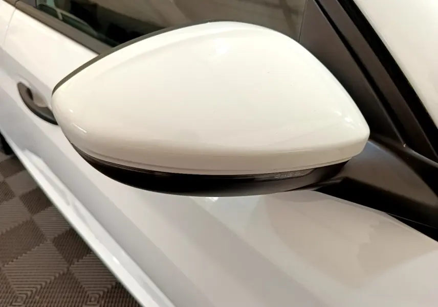 Rétroviseur droit blanc de la Peugeot 208 1.2 PT 75 S&S Premium 2021, vue rapprochée sur la portière blanche.