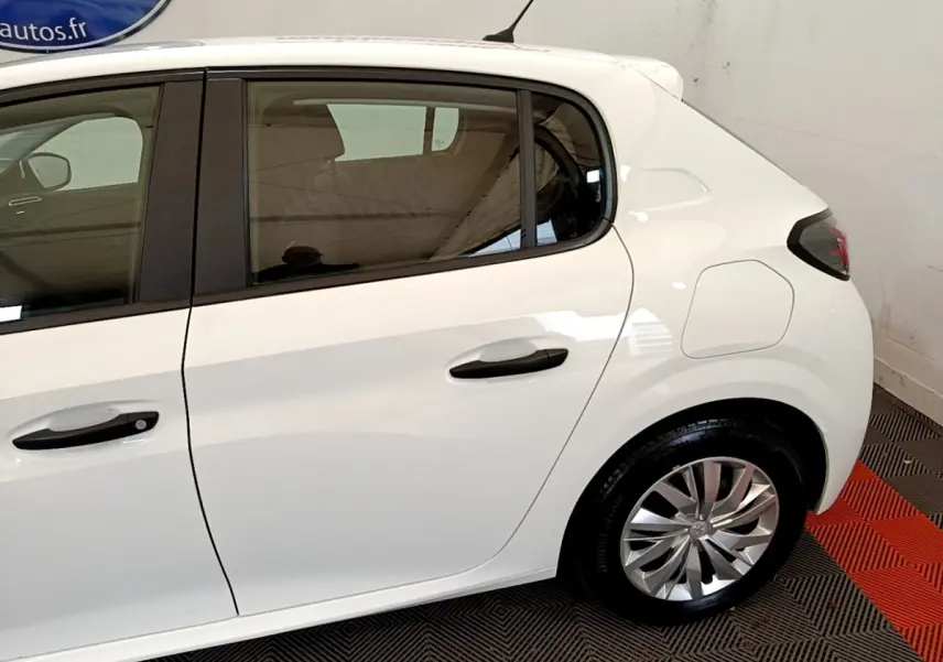 Vue latérale côté droit d'une Peugeot 208 blanche, mettant en valeur la porte arrière et la roue arrière.
