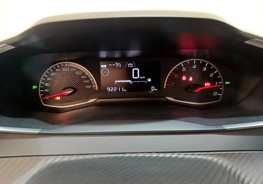 Tableau de bord de Peugeot 208 blanc, affichage numérique central avec compte-tours et vitesse à 0 km/h.