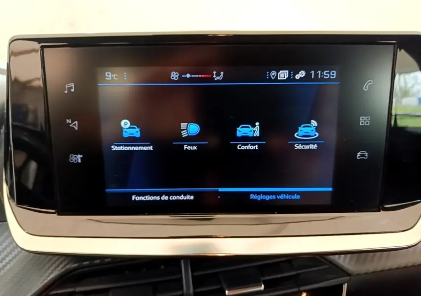 Écran tactile central de la Peugeot 208 2021 affichant les options stationnement, feux, confort et sécurité.