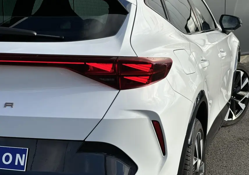 Vue 3/4 arrière droite d'une CUPRA Formentor blanc Neige avec feux arrière Tri-LED et jantes alliage 19 pouces Sandstorm.