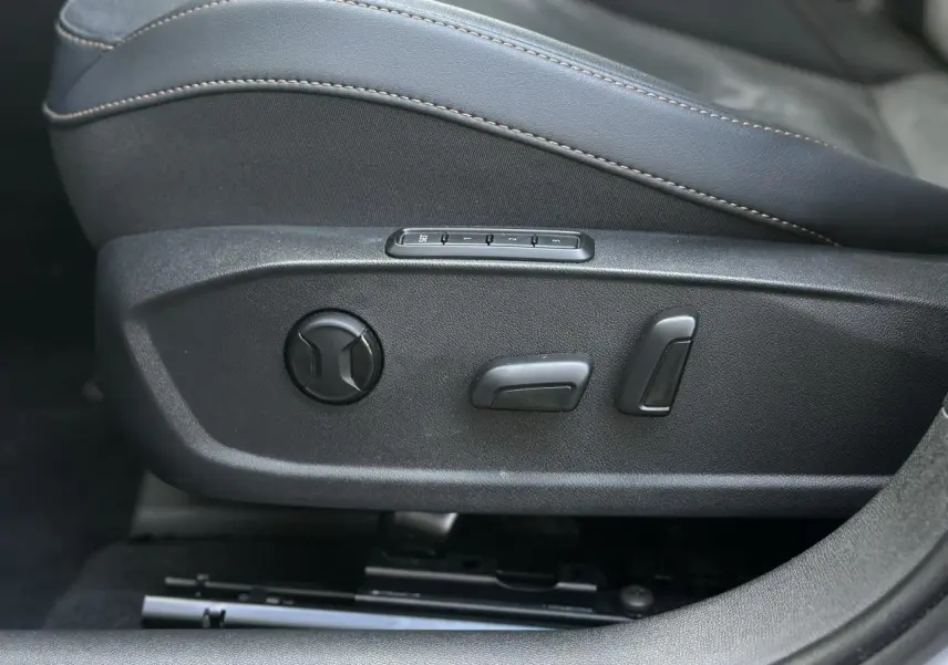 Détail des commandes de réglage électrique du siège conducteur en suédine noir sur CUPRA Formentor blanc.
