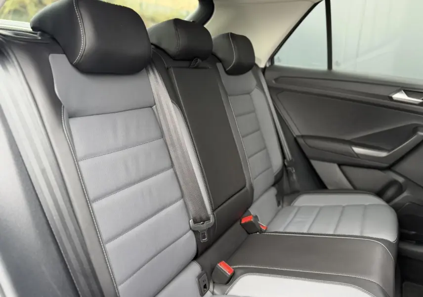 Vue latérale intérieure des sièges arrière en cuir gris et noir du Volkswagen T-Roc 2024 Style Exclusive.