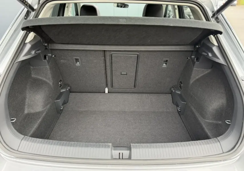 Coffre ouvert vue arrière d’un Volkswagen T-Roc argent Pyrite, montrant l’espace de chargement et la tablette cache-bagages.