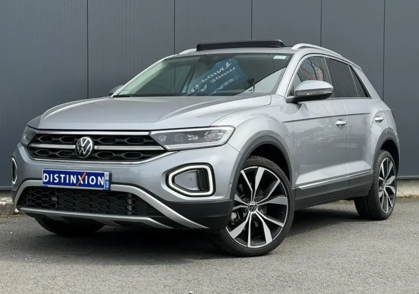 Volkswagen T-Roc 1.5 TSI argent pyrite, vue 3/4 avant droit, jantes alliage 19 pouces et toit ouvrant.