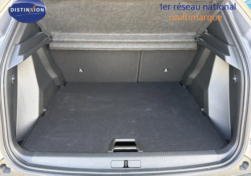 Coffre ouvert en vue arrière d'un Peugeot 2008 gris Artense avec toit noir, montrant l'espace de chargement vide.