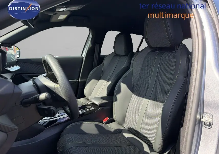Vue intérieure côté conducteur du Peugeot 2008 1.2 HYBRID 145 GT gris Artense, sièges en cuir noir avec surpiqûres contrastées.