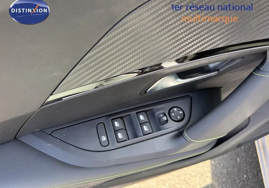 Détail de la porte côté gauche de la Peugeot 2008 1.2 Hybrid 145 GT 2026 avec insert carbone et surpiqûres vertes.