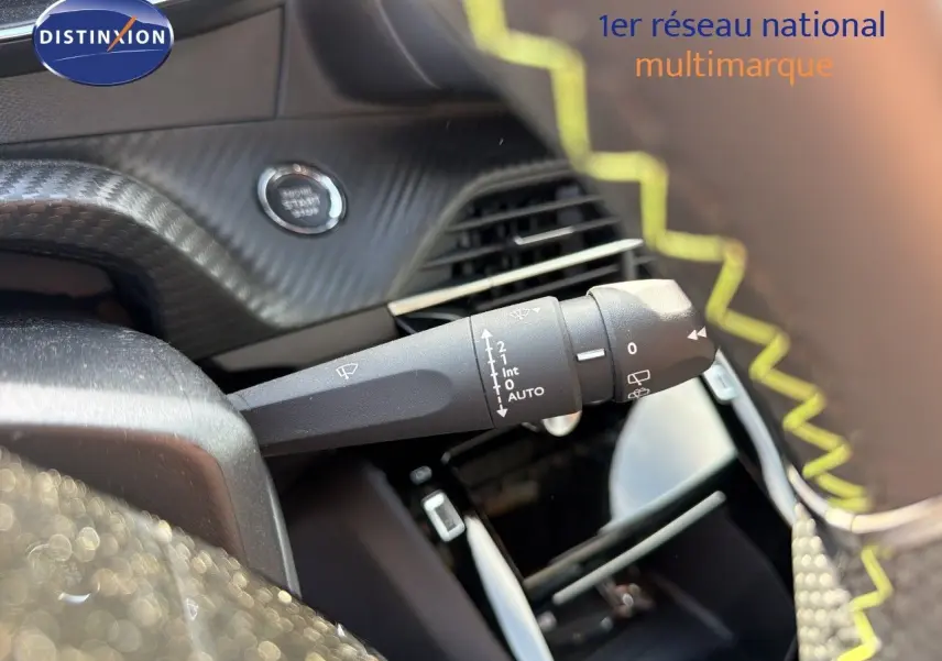 Gros plan sur la commande d'essuie-glace à gauche du volant, intérieur noir avec surpiqûres jaunes du Peugeot 2008 gris Artense.