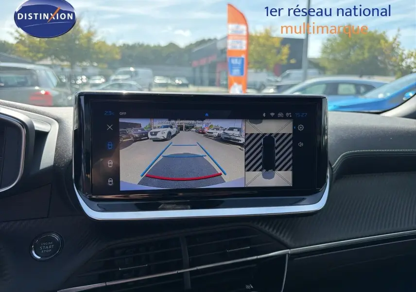 Vue intérieure du tableau de bord du Peugeot 2008 gris Artense, écran tactile affichant la caméra de recul et l'aide au stationnement.