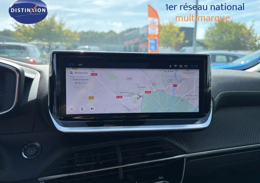 Vue intérieure centrée sur l'écran tactile du tableau de bord du Peugeot 2008, affichant un GPS en plein jour.