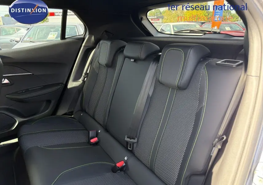 Vue intérieure arrière droite des sièges noirs avec surpiqûres vertes du Peugeot 2008 1.2 Hybrid 145 GT 2026.