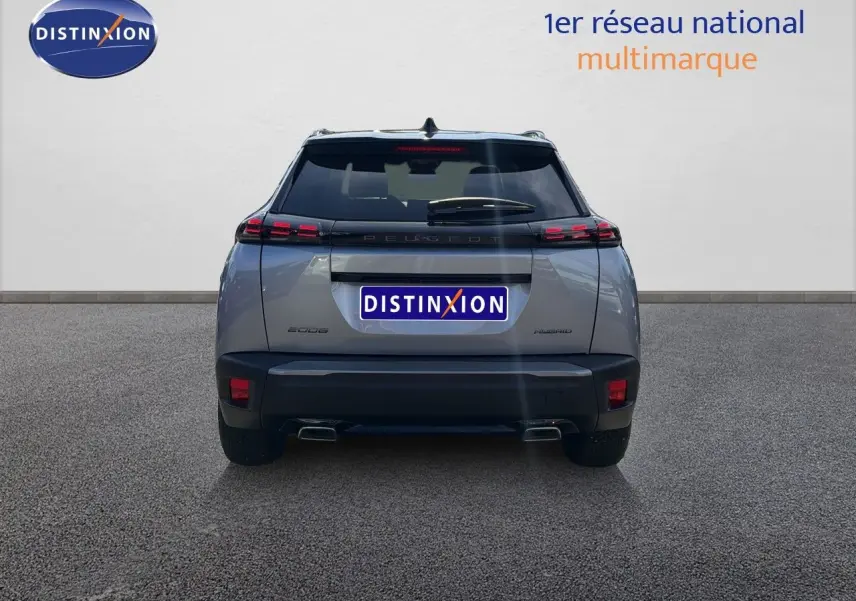 Vue arrière d'un Peugeot 2008 gris Artense avec toit noir, mettant en valeur ses feux LED et double sortie d'échappement.