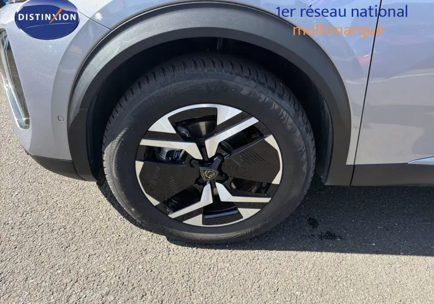 Gros plan sur la roue avant gauche du Peugeot 2008 gris Artense avec jante noire et argentée en extérieur.