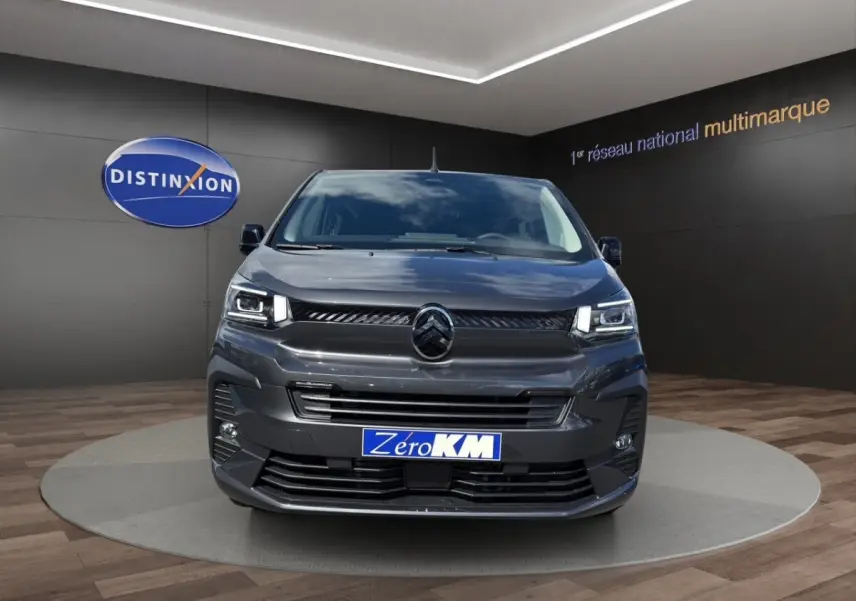Vue avant d'un Citroën Jumpy gris foncé avec calandre noire et phares LED dans un showroom.
